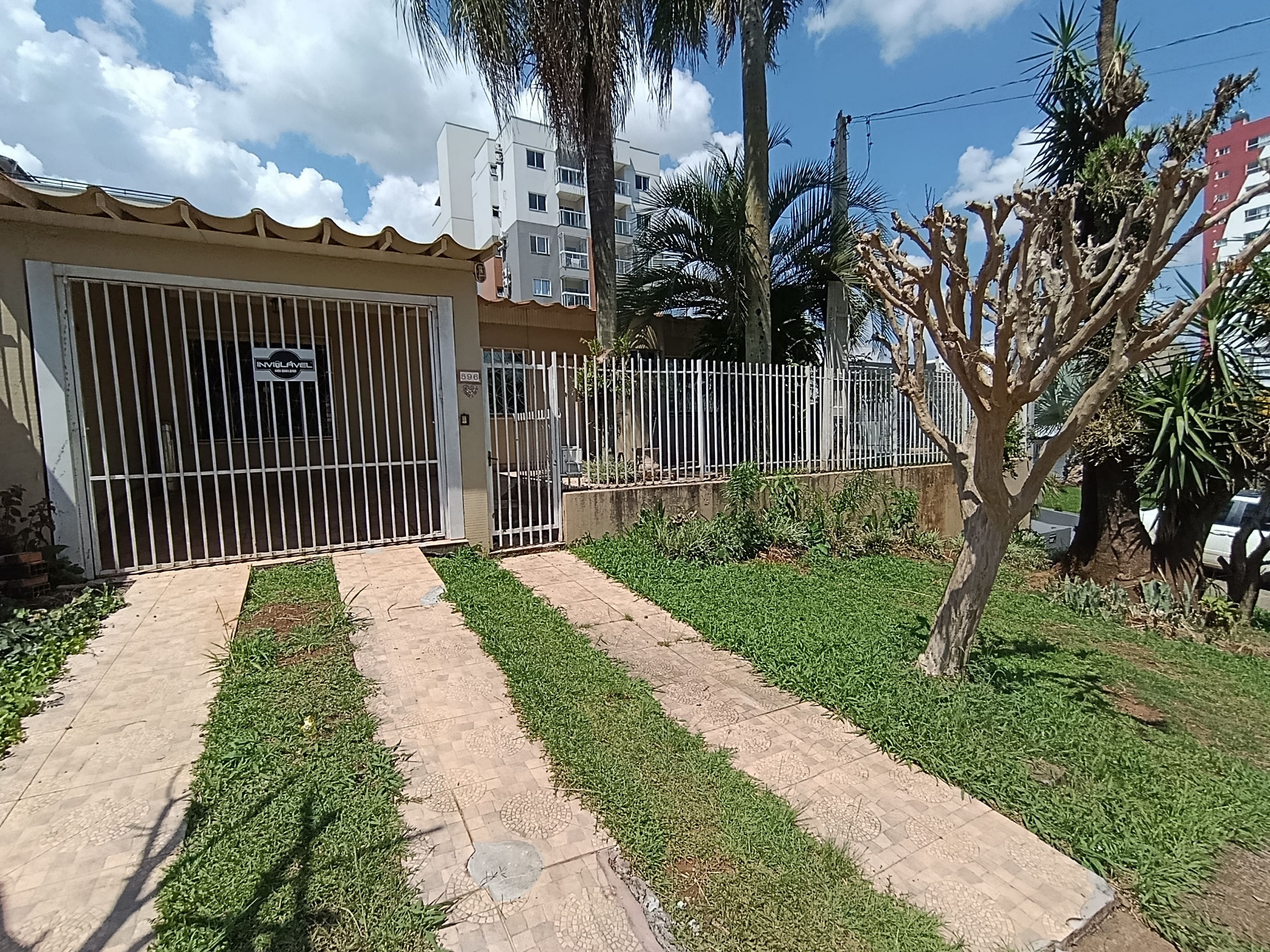 Cozinha com Pia, Armários e Mesa com Cadeiras.